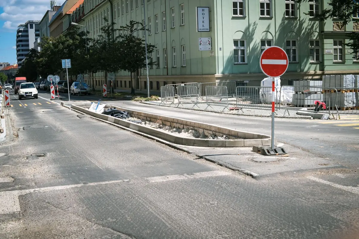 Znak zakazu wjazdu B-2 na przenośnej podstawie przy przebudowie ulicy w mieście, za nim ogrodzenie placu budowy